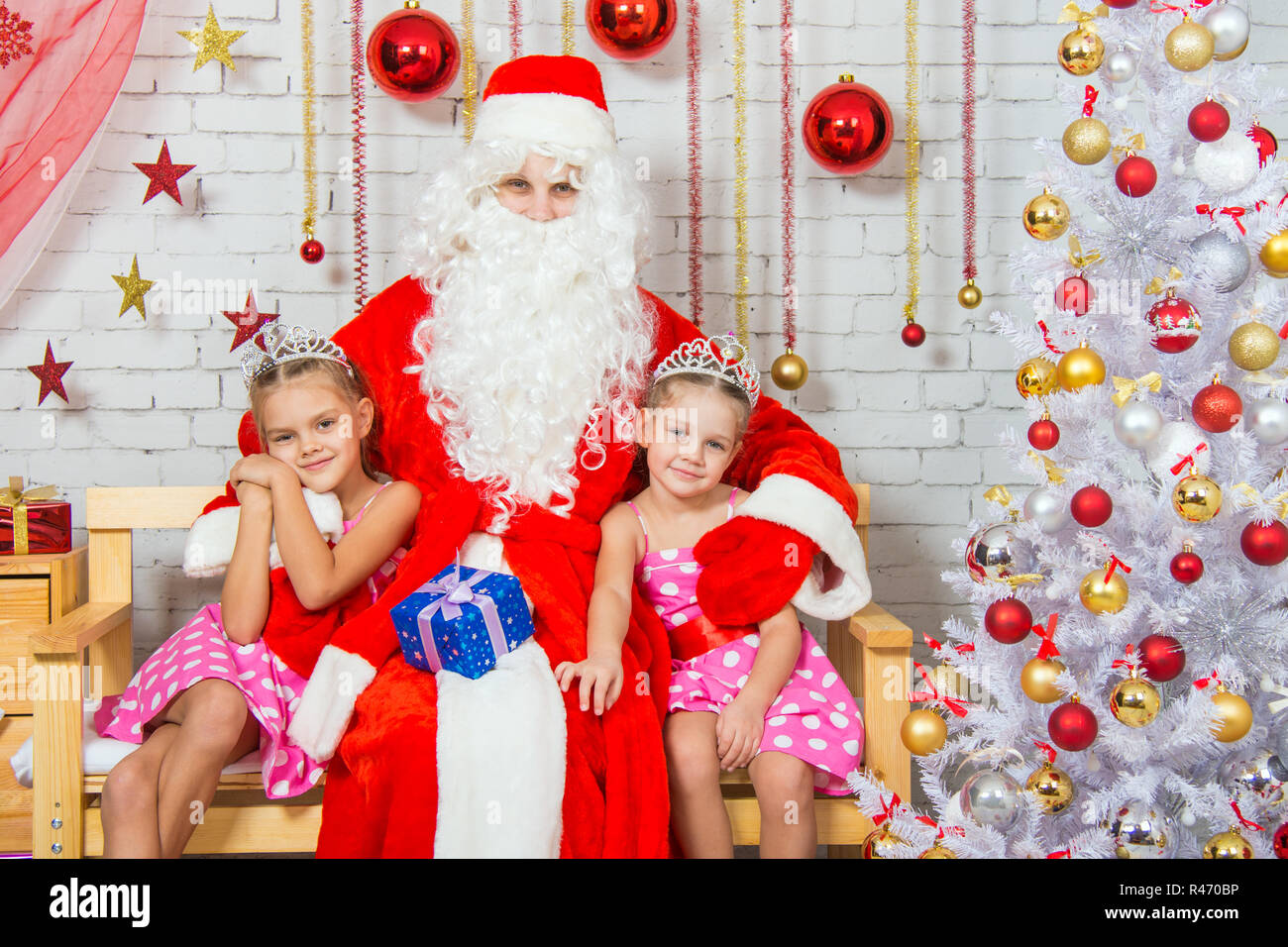 Santa Claus hugging deux soeurs filles Banque D'Images