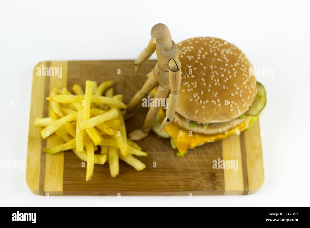 Poupée en bois debout sur un hamburger Banque D'Images