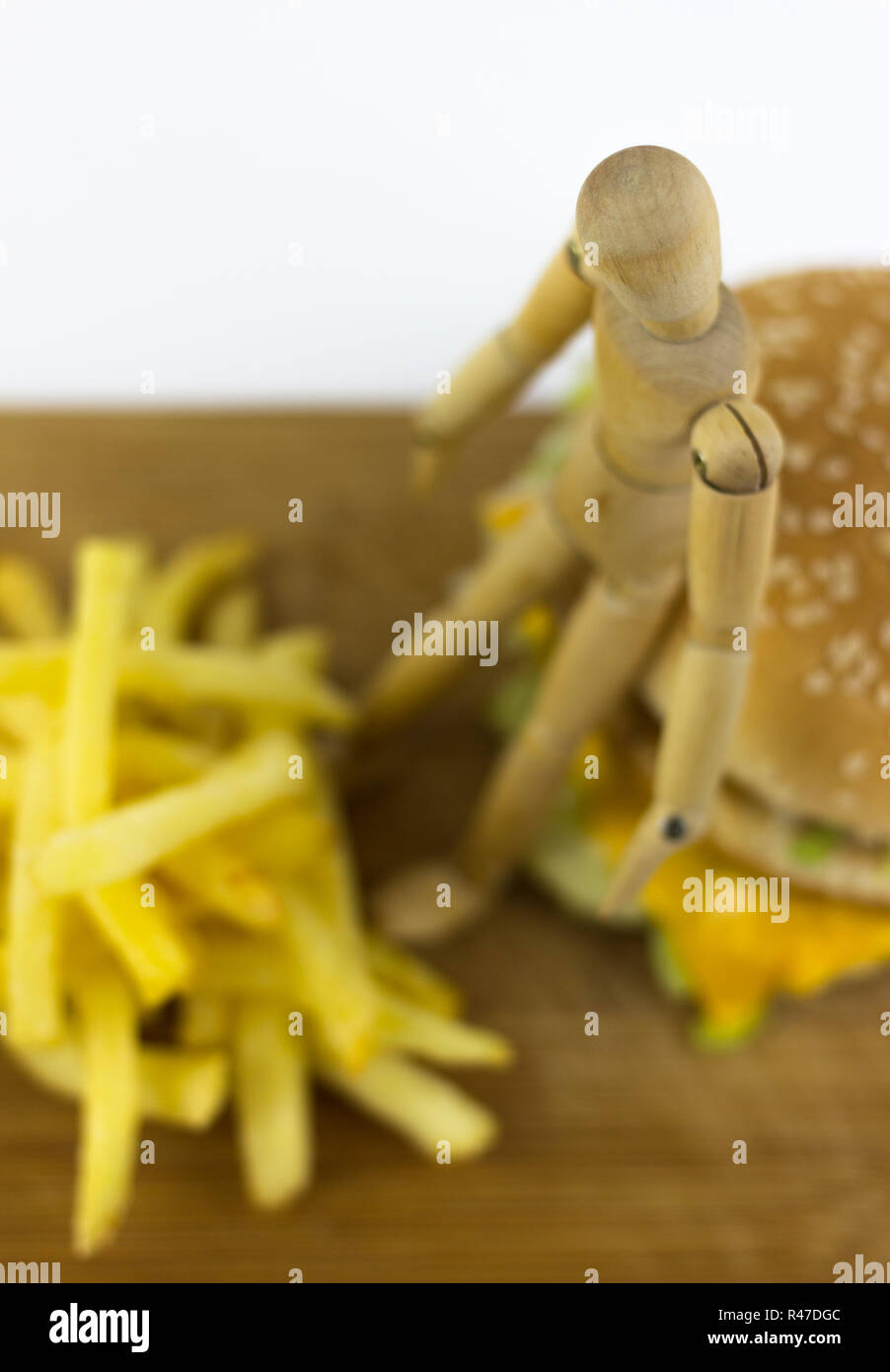 Poupée en bois debout sur un hamburger Banque D'Images