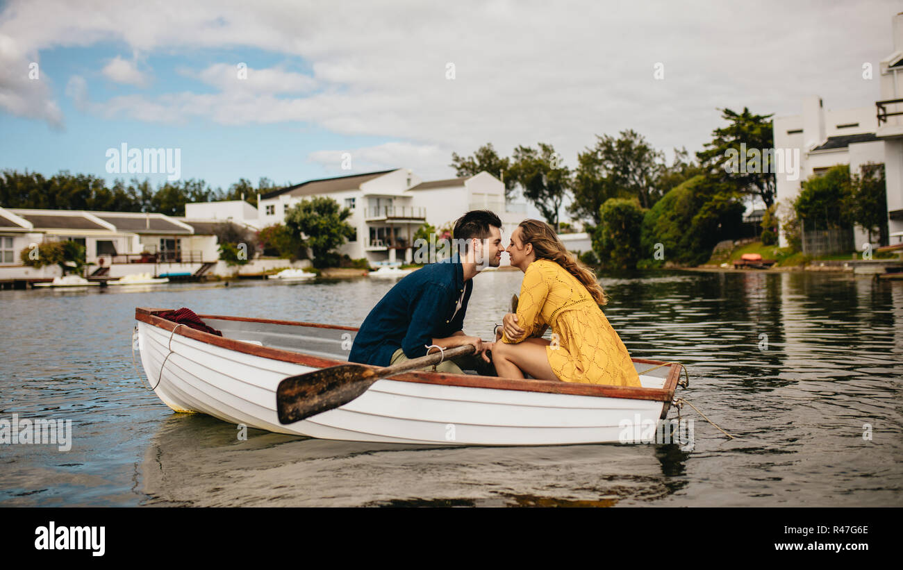 Jeune couple sur une date assis dans un bateau. Couple amoureux assis dans un bateau en face de l'autre. Banque D'Images
