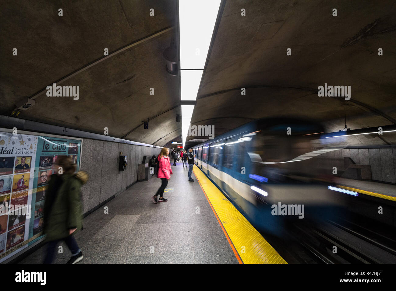 Montréal, Canada - le 3 novembre 2018 : personnes en attente d'un métro à la station Côte-des-Neiges, plate-forme de la ligne bleue du métro, alors qu'un train approche, avec un Banque D'Images