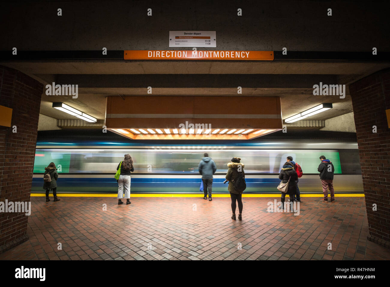 Montréal, Canada - le 3 novembre 2018 : personnes en attente d'un métro à la station Snowdon, plate-forme de la ligne orange du métro, tandis qu'un train approche, avec une vitesse Banque D'Images