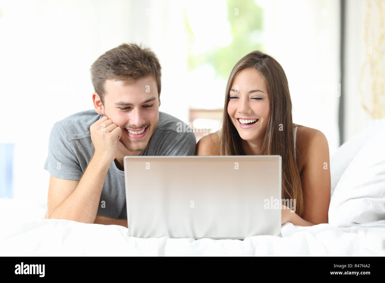 Couple de regarder des vidéos sur un ordinateur portable à la maison Banque D'Images