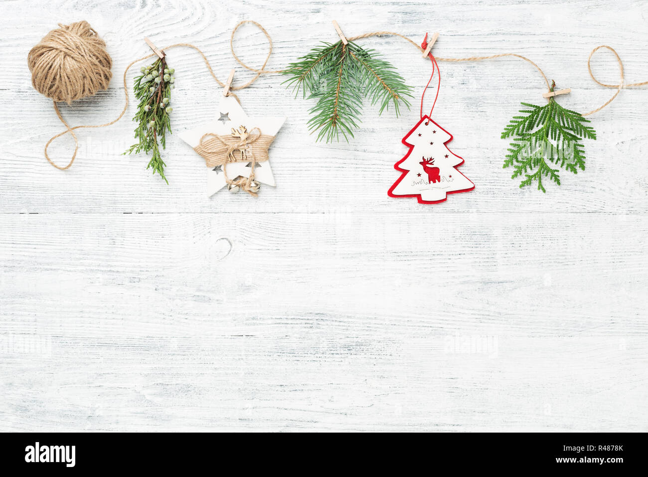 Guirlande de fête décorations de Noël et des branches d'arbres conifères contre fond blanc, copie de l'espace, style rustique. Banque D'Images