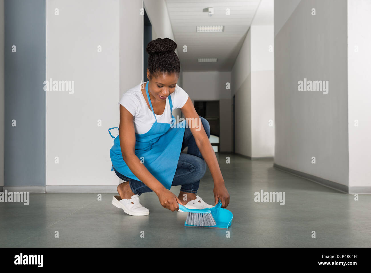 Woman Sweeping étage avec petit balai Banque D'Images