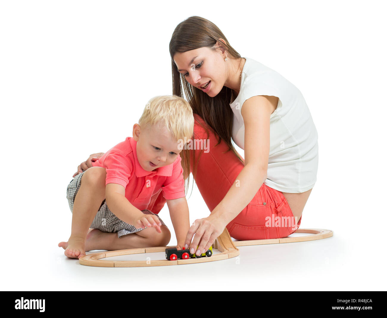 Jeune mère avec son enfant fils jouer jouets ferroviaires. Isolé sur fond blanc Banque D'Images