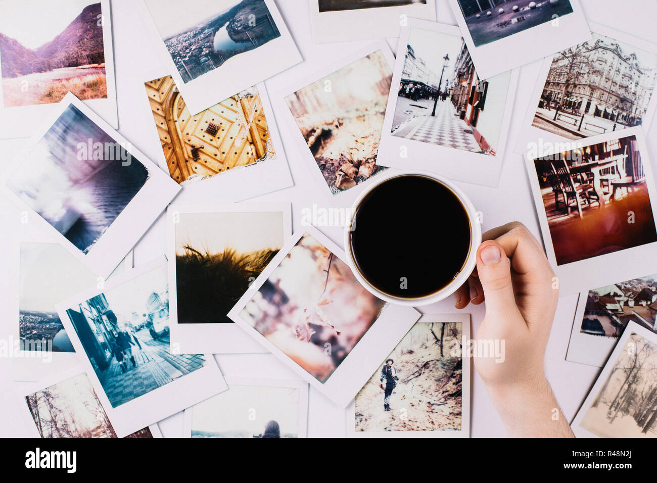 Une main tenant une tasse de café entre une bande de 2006 à 1972 Banque D'Images