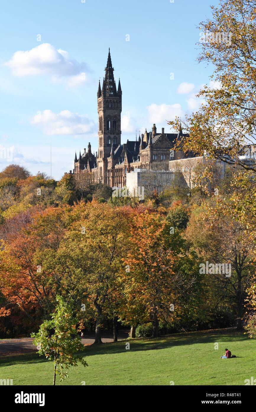 Un étudiant se détend sur l'herbe du parc Kelvingrove en automne au-dessous de l'Université de Glasgow, Écosse, Royaume-Uni, Europe Banque D'Images