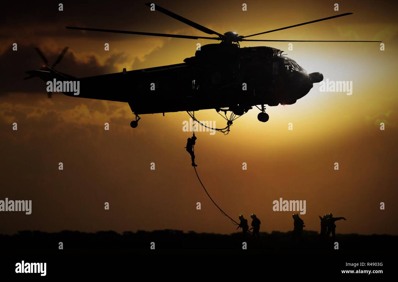 La chute de l'hélicoptère militaire pendant le coucher du soleil Banque D'Images