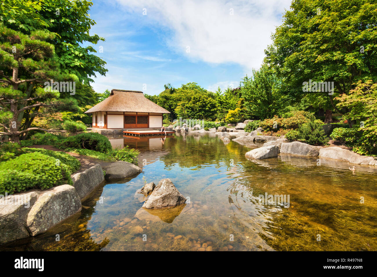 Belle vue sur jardin japonais traditionnel avec étang et maison de thé Banque D'Images