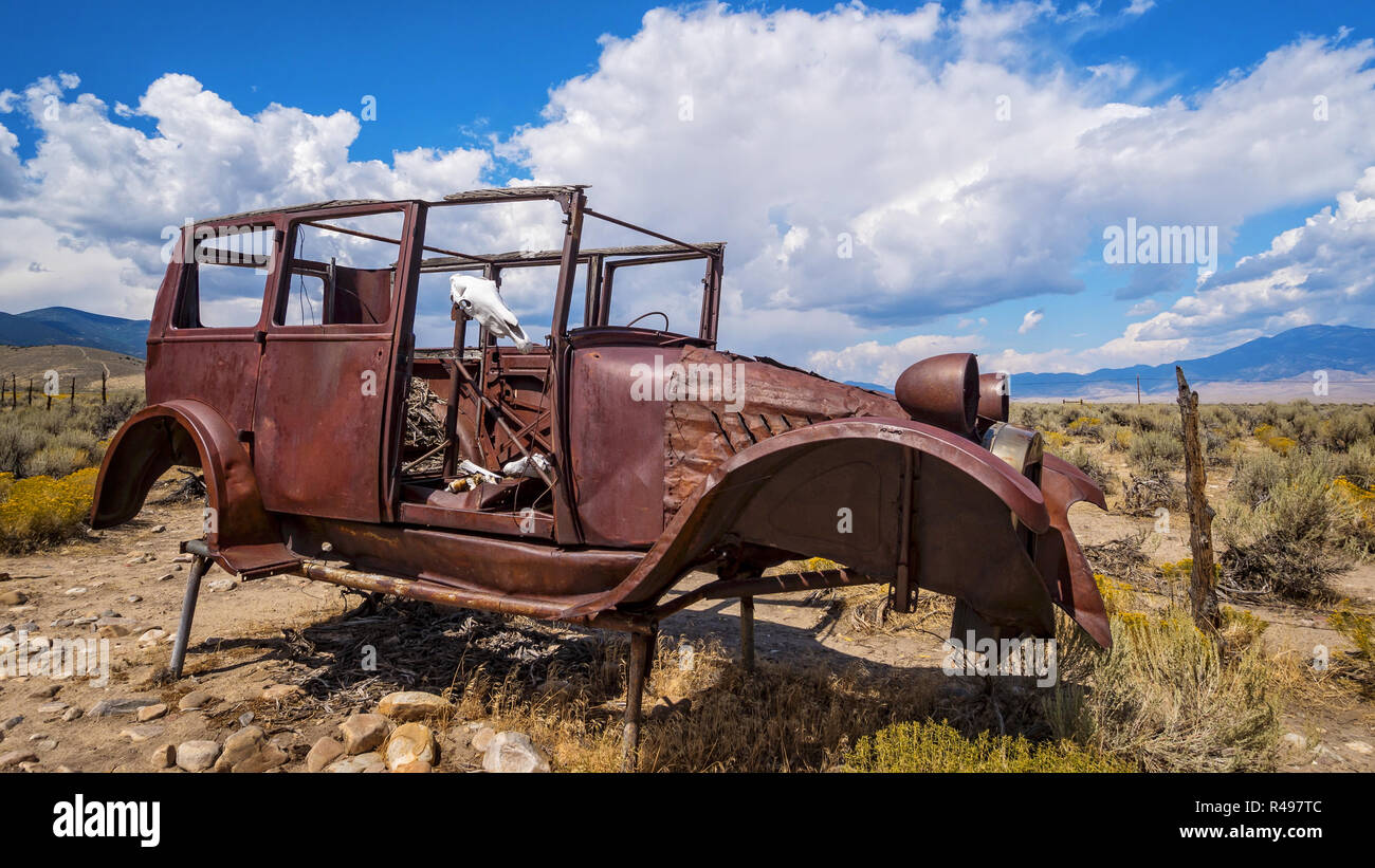 Voitures anciennes rouillées et crâne de vache s'asseoir dans le désert du Parc National du Grand Bassin à l'est dans le Nevada Banque D'Images