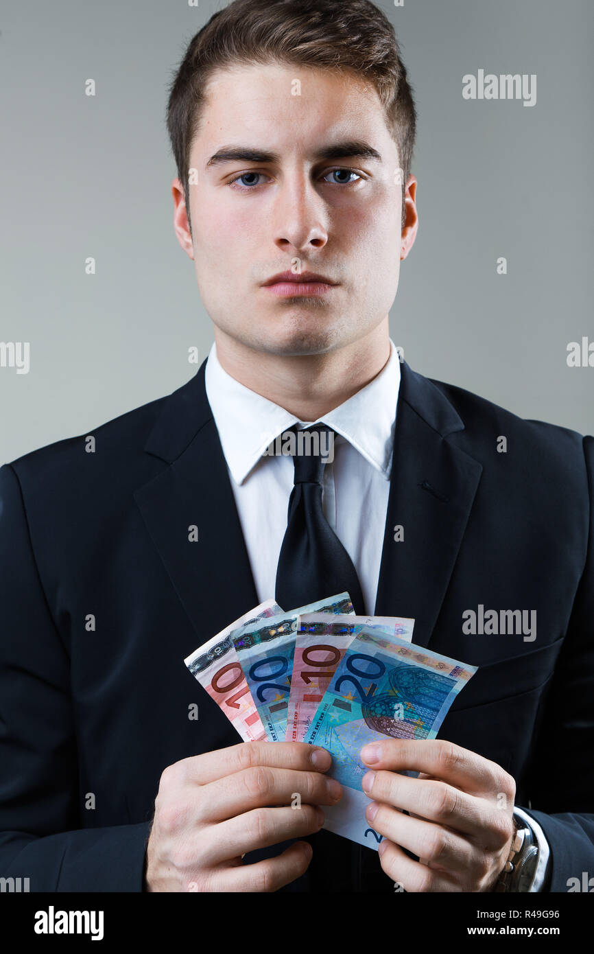 Jeune homme dans la soirée de la détention de monnaie. Banque D'Images