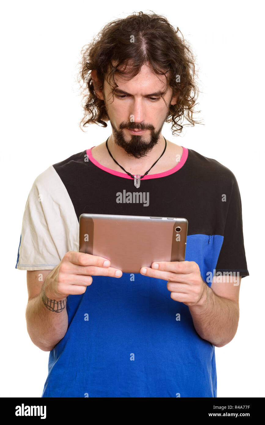 Jeune homme tient une tablette tactile sur fond blanc isolé. La tablette  numérique de grande taille