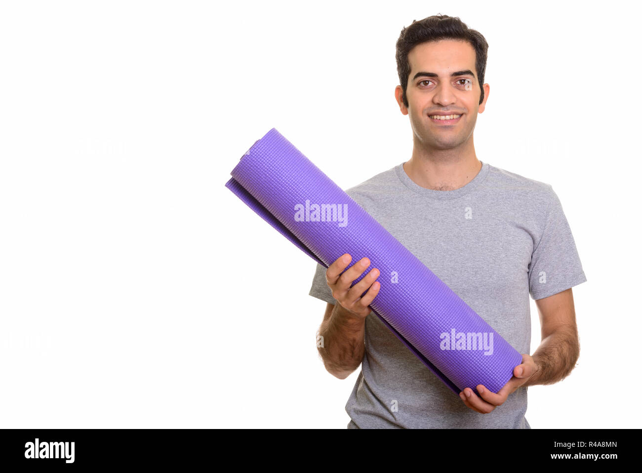Young happy man holding Persique tapis yoga prêt pour salle de sport Banque D'Images