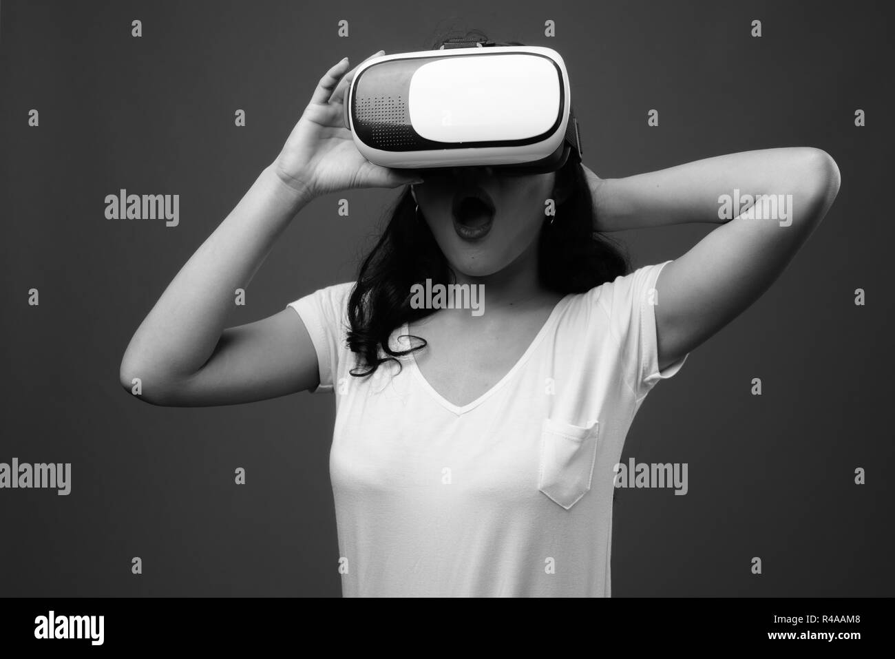 Belle jeune femme asiatique à l'aide de lunettes de réalité virtuelle Banque D'Images