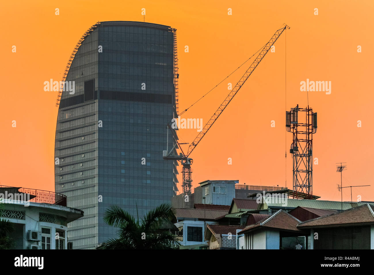 Tour moderne et la grue près de la rivière dans le centre de cette ville en évolution rapide ; Riverfront, Phnom Penh, Cambodge Banque D'Images