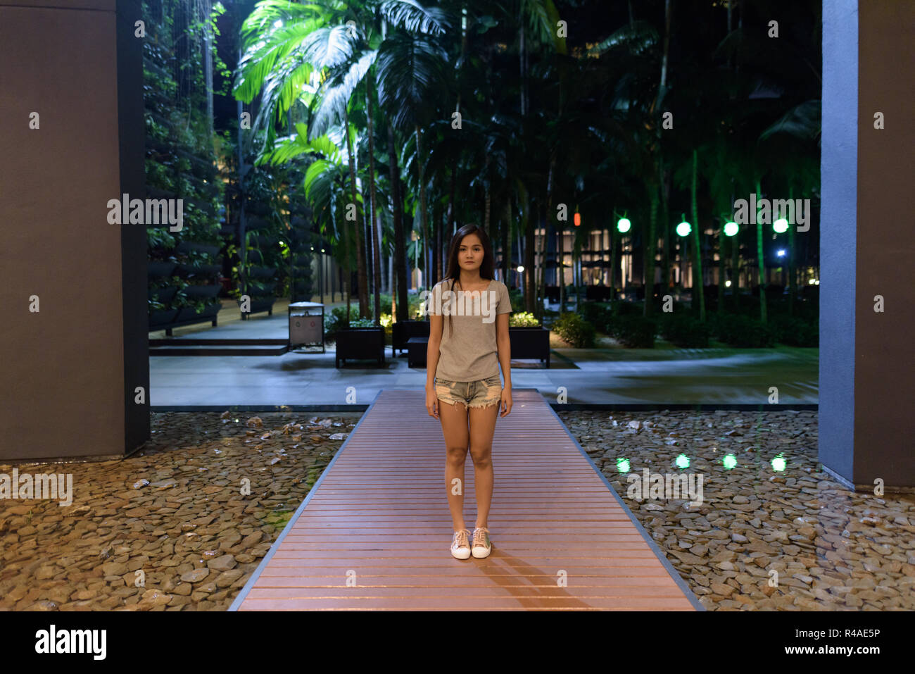 Belle asiatique Jeune femme debout sur le trottoir de bois de la Banque D'Images