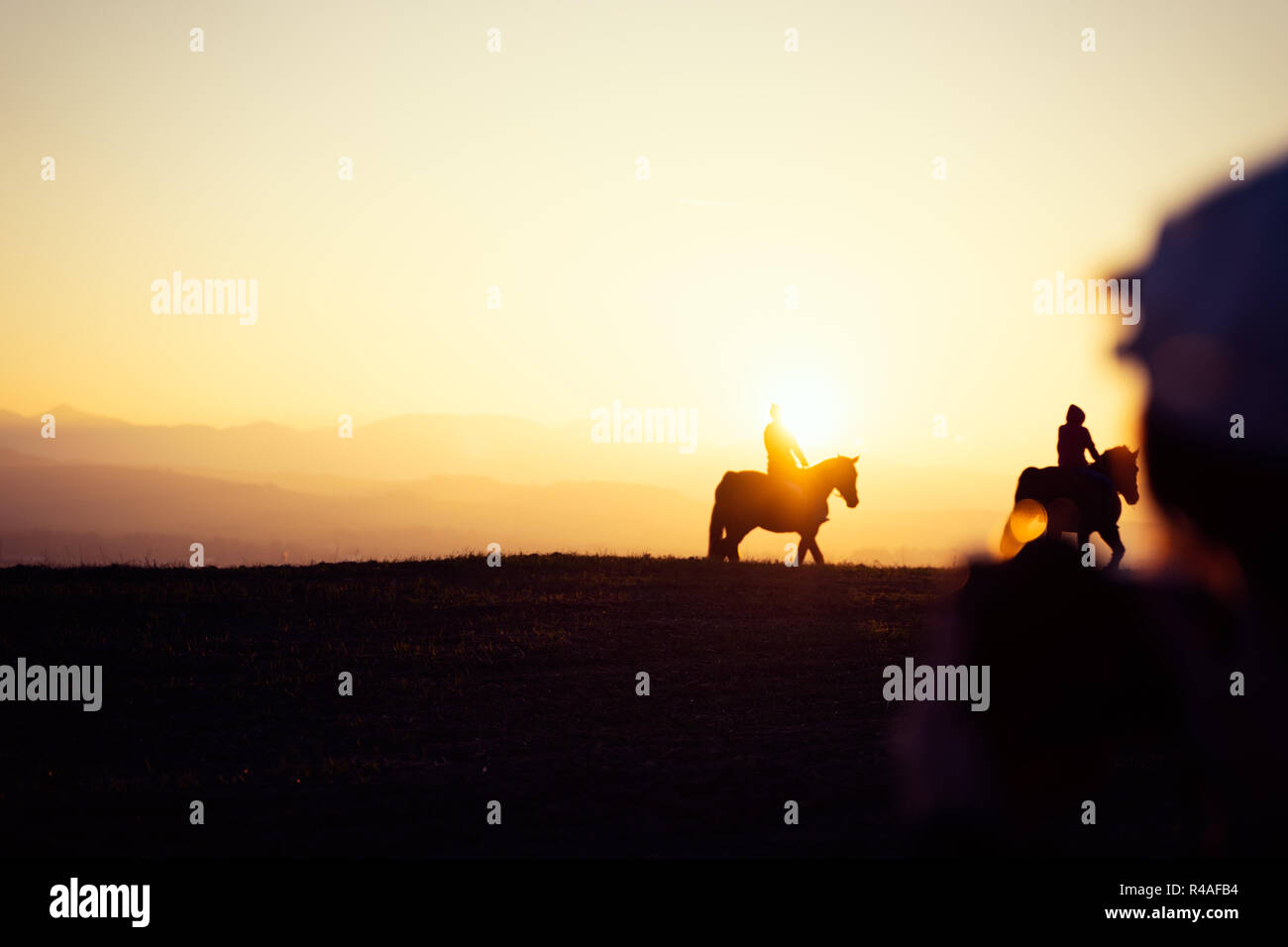Deux cavaliers sur la silhouette sur le coucher du soleil, beau paysage paisible Banque D'Images