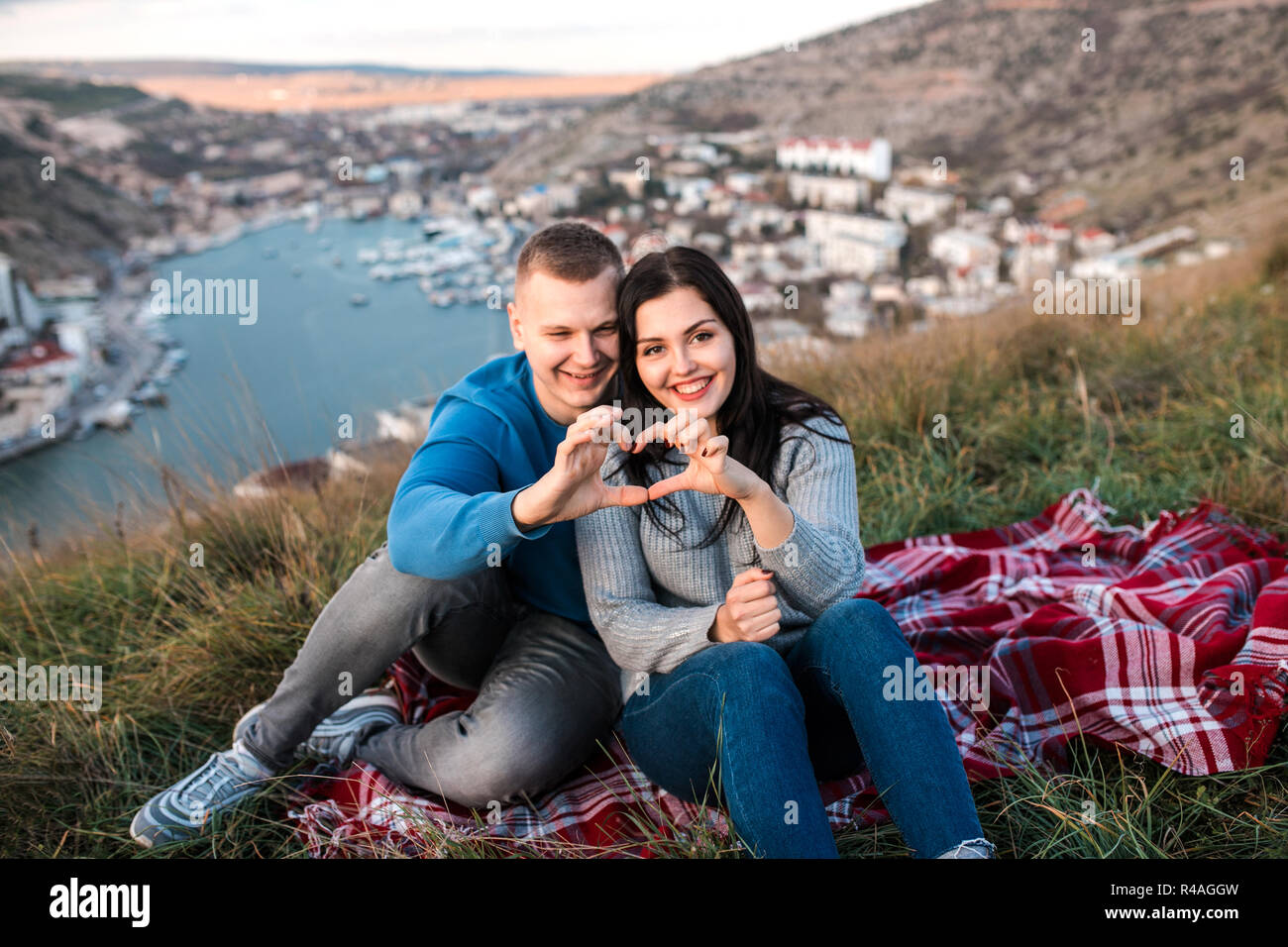 Couple aimant faire de cœur par des doigts à l'extérieur. Banque D'Images