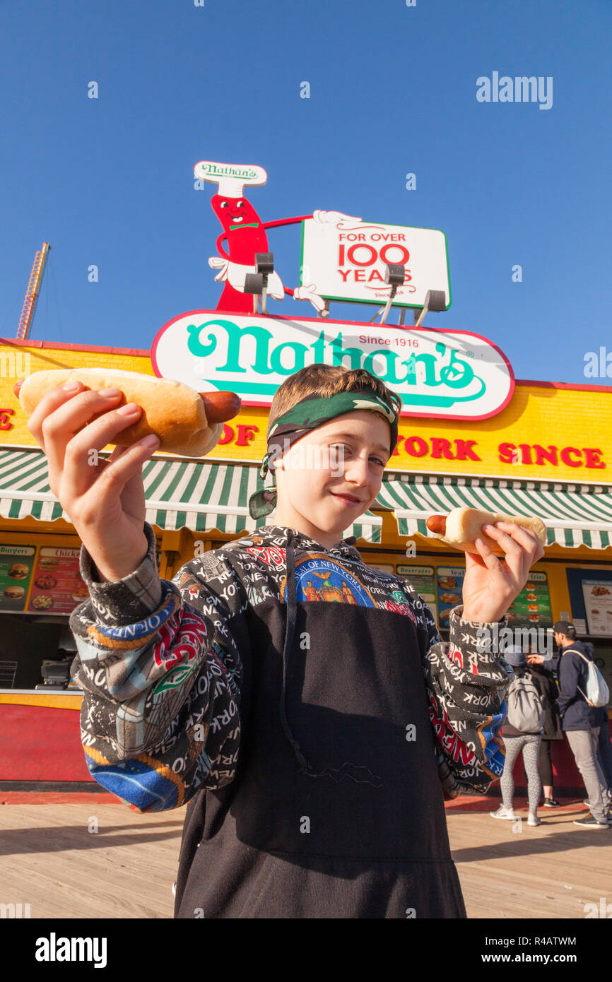 Un garçon de neuf ans avec un hot-dog, Nathan's, Coney Island, Brooklyn, New York, États-Unis d'Amérique. Banque D'Images