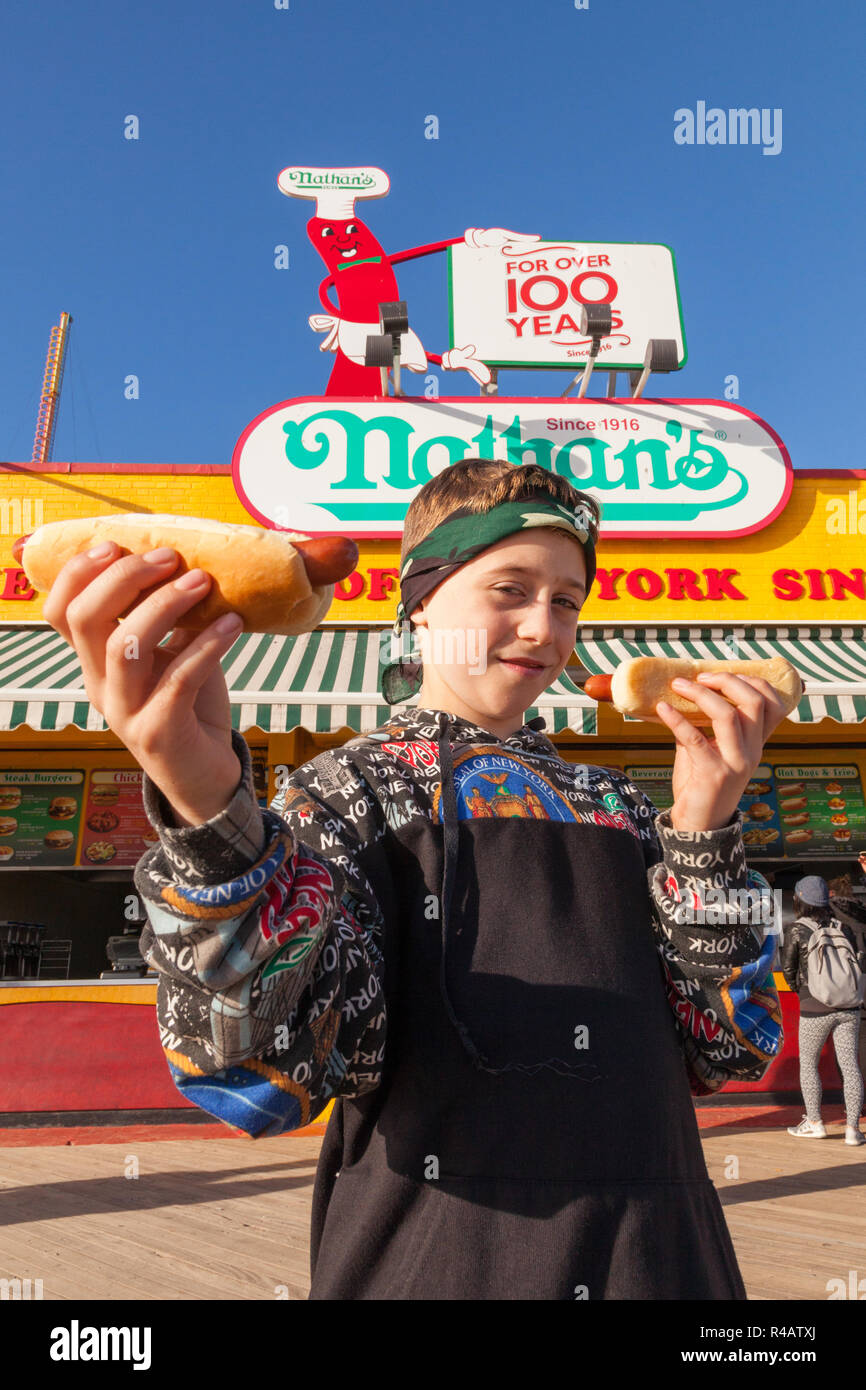 Un garçon de neuf ans avec un hot-dog, Nathan's, Coney Island, Brooklyn, New York, États-Unis d'Amérique. Banque D'Images