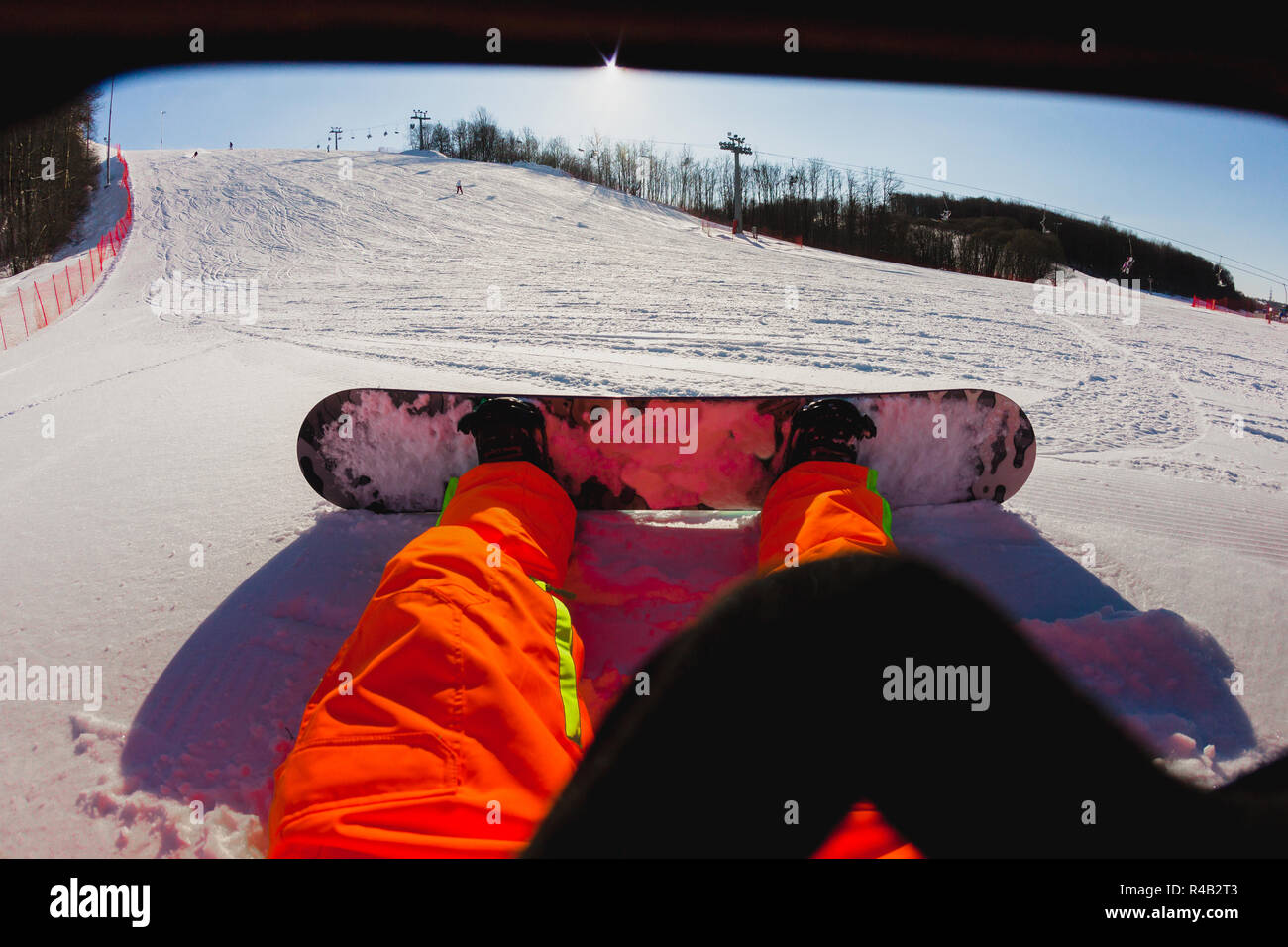 Point de vue d'un homme snowboarder assis sur la neige Banque D'Images