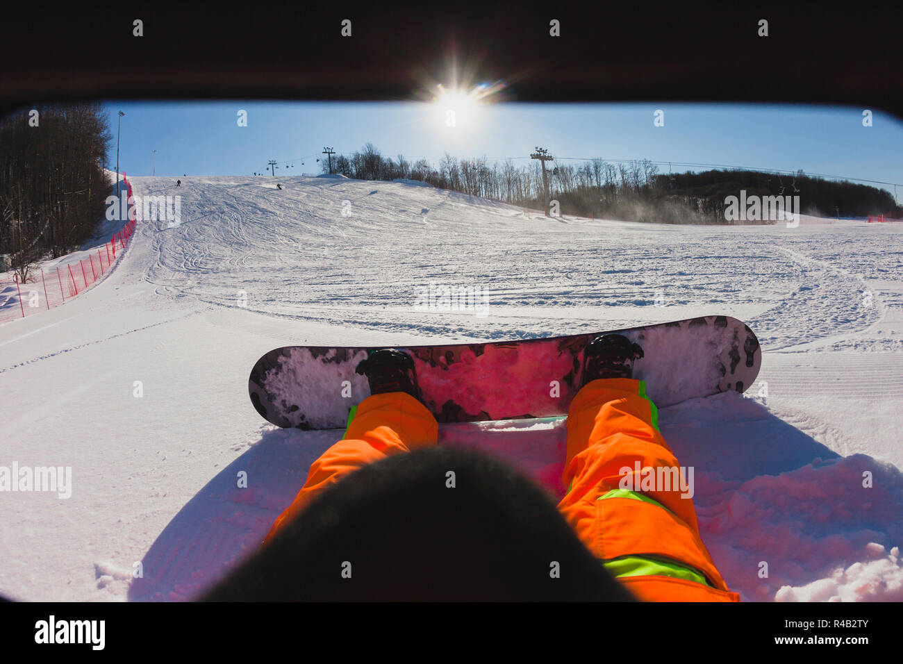 Point de vue d'un homme snowboarder assis sur la neige Banque D'Images