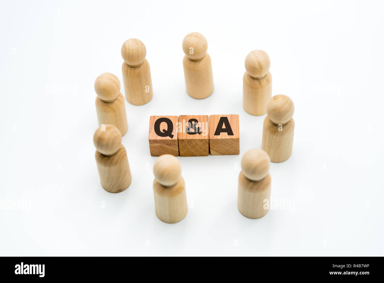 Figures en bois comme travail d'équipe en cercle autour de l'acronyme Q&R Questions et réponses, isolé sur fond blanc, concept minimaliste Banque D'Images