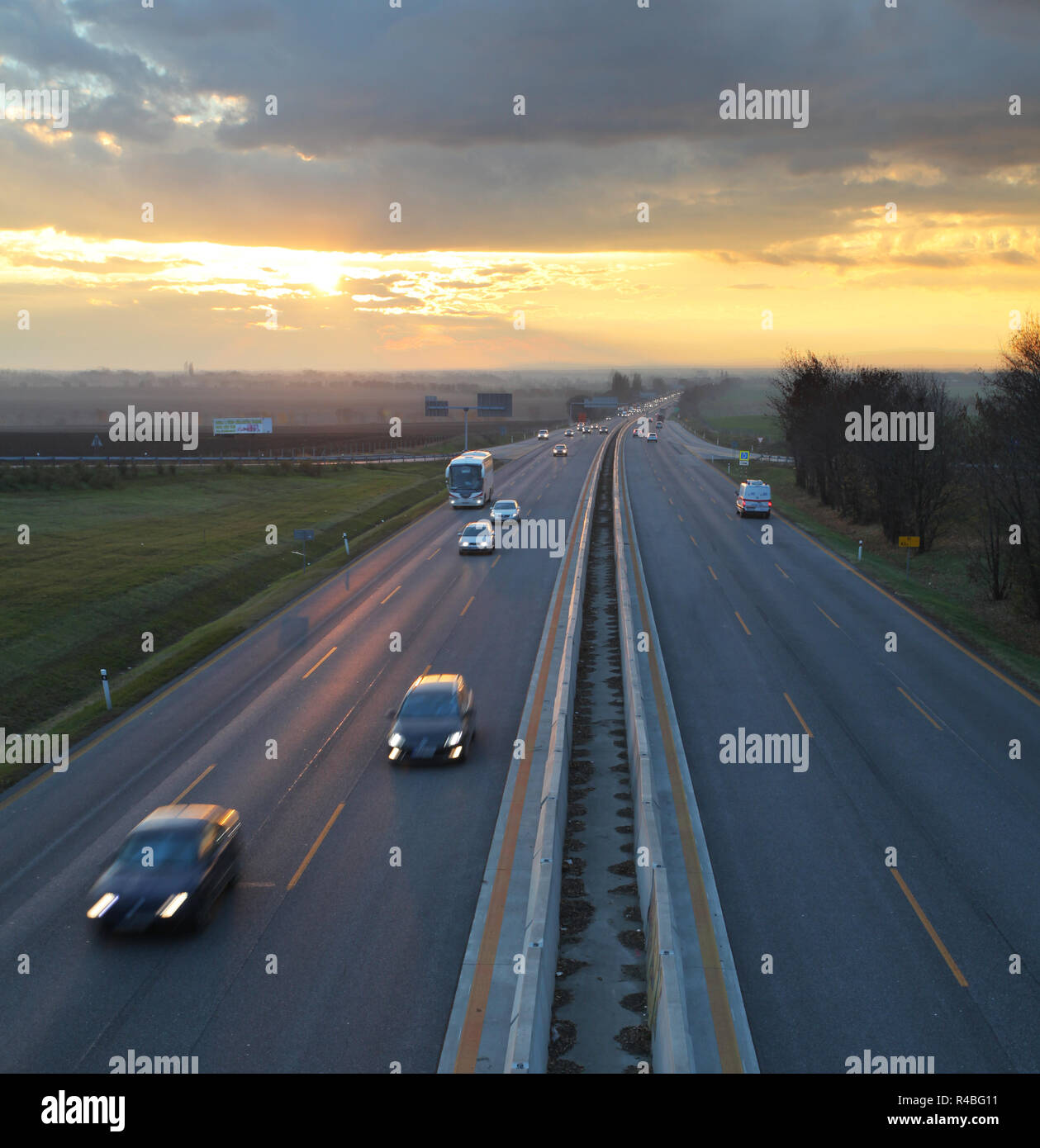 La circulation automobile contre le fond coucher de soleil. Banque D'Images