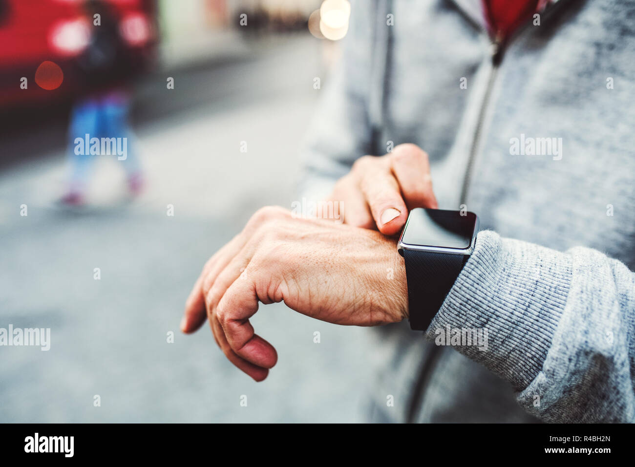 Un close-up de méconnaissable homme debout à l'extérieur en ville, à l'aide de smartwatch. Banque D'Images
