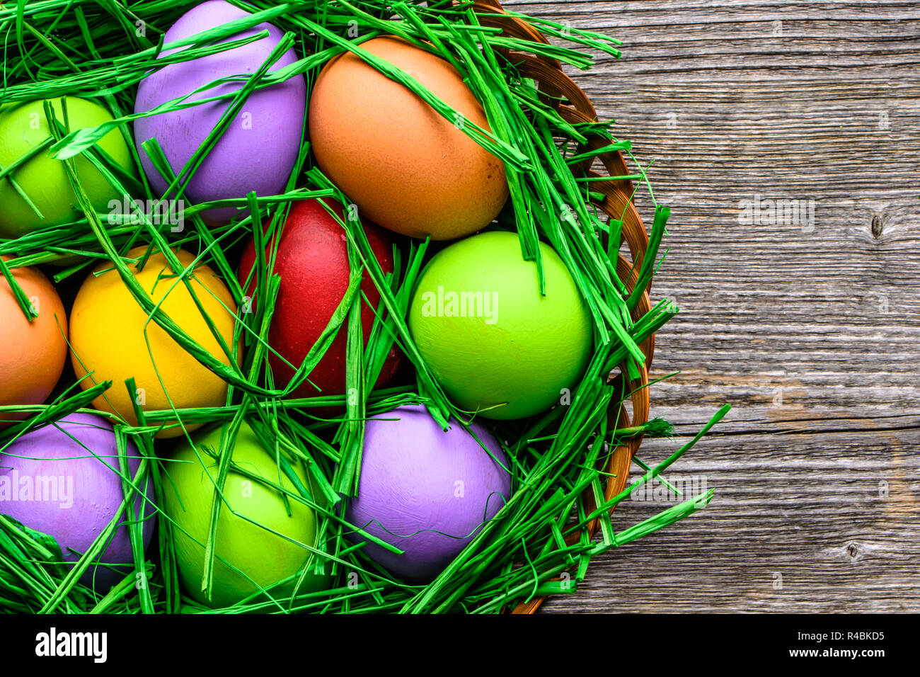 Fond de bois avec des œufs de Pâques peints dans des couleurs éclatantes Banque D'Images