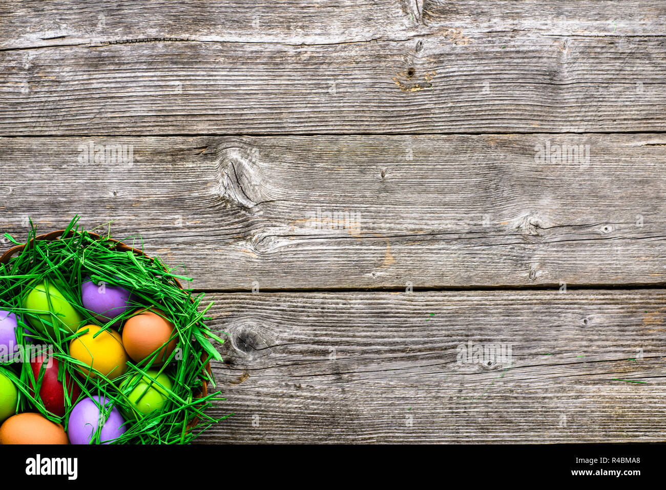 Panier avec des oeufs de pâques, décoration de fête colorés sur fond de bois Banque D'Images