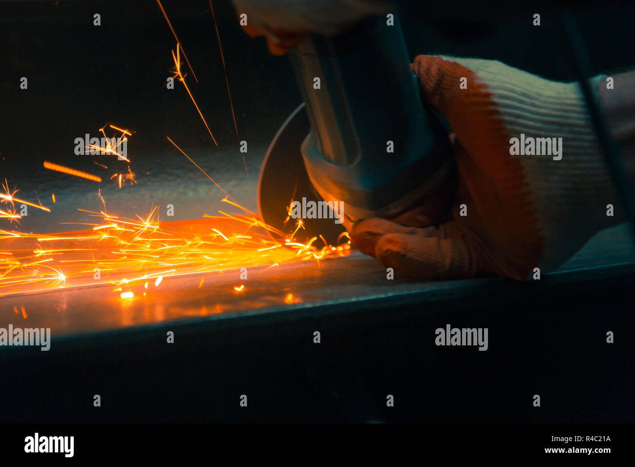 Les mains d'un mécanicien grinder dans les gants au travail Banque D'Images