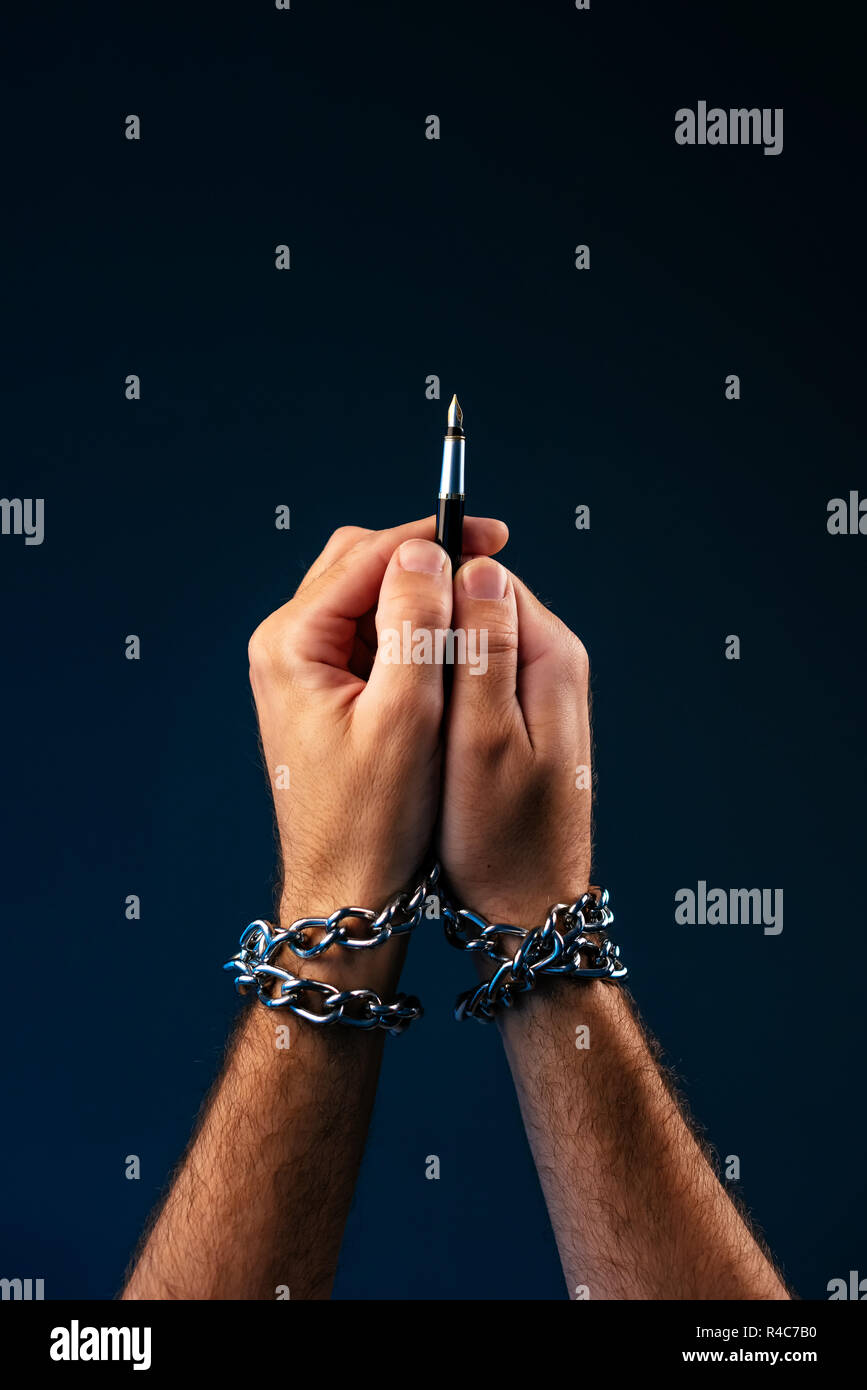 La liberté de la presse et du journalisme, conceptual image avec un crayon dans la main des hommes avec des chaînes, l'image clé faible Banque D'Images
