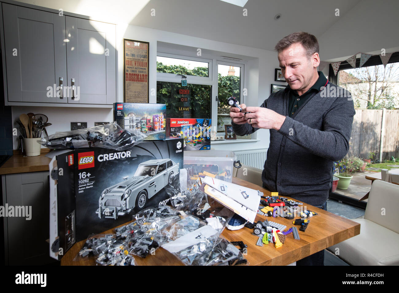 Homme d'âge moyen à la maison lego construction en Angleterre, comme les adultes, sont l'admission à la dépendance à l'édifice en brique de phénomène, Royaume-Uni. Banque D'Images