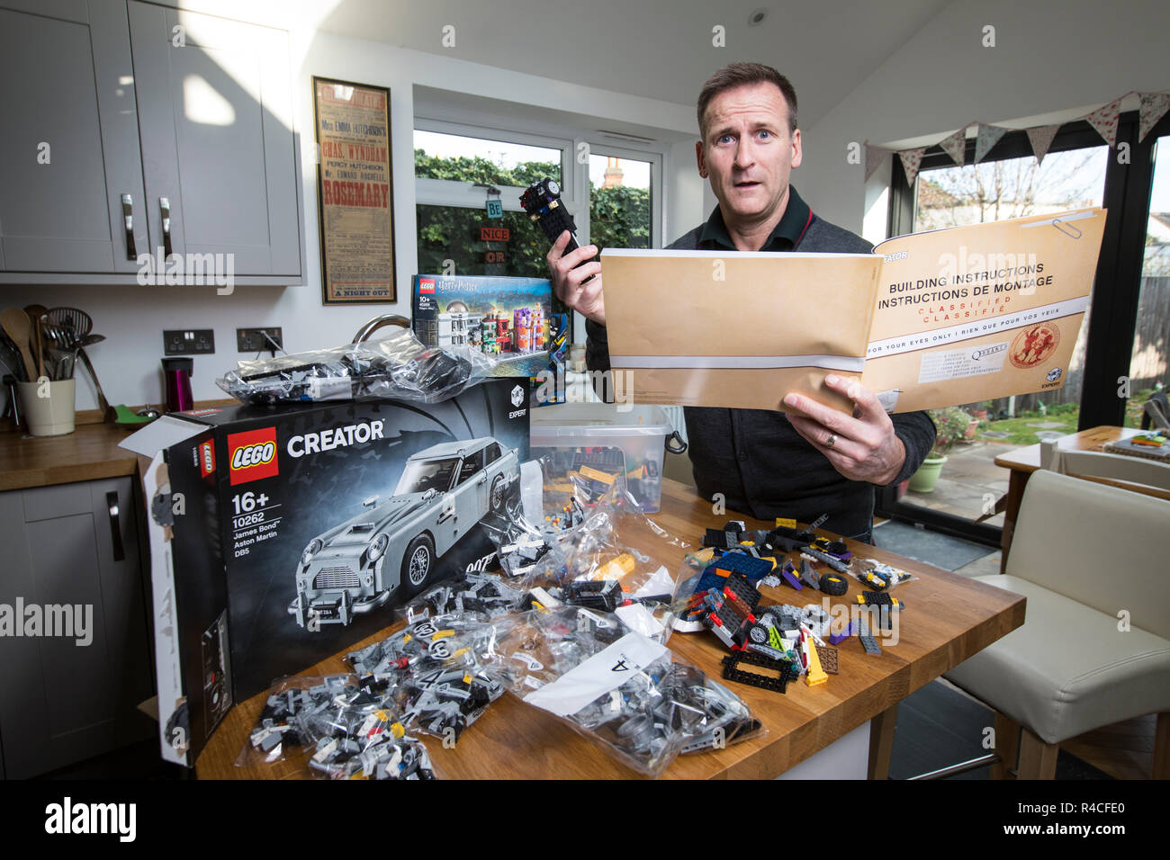 Homme d'âge moyen à la maison lego construction en Angleterre, comme les adultes, sont l'admission à la dépendance à l'édifice en brique de phénomène, Royaume-Uni. Banque D'Images