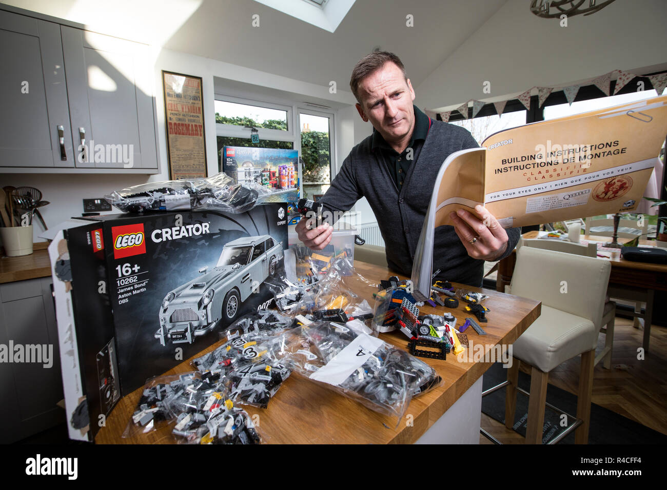 Homme d'âge moyen à la maison lego construction en Angleterre, comme les adultes, sont l'admission à la dépendance à l'édifice en brique de phénomène, Royaume-Uni. Banque D'Images