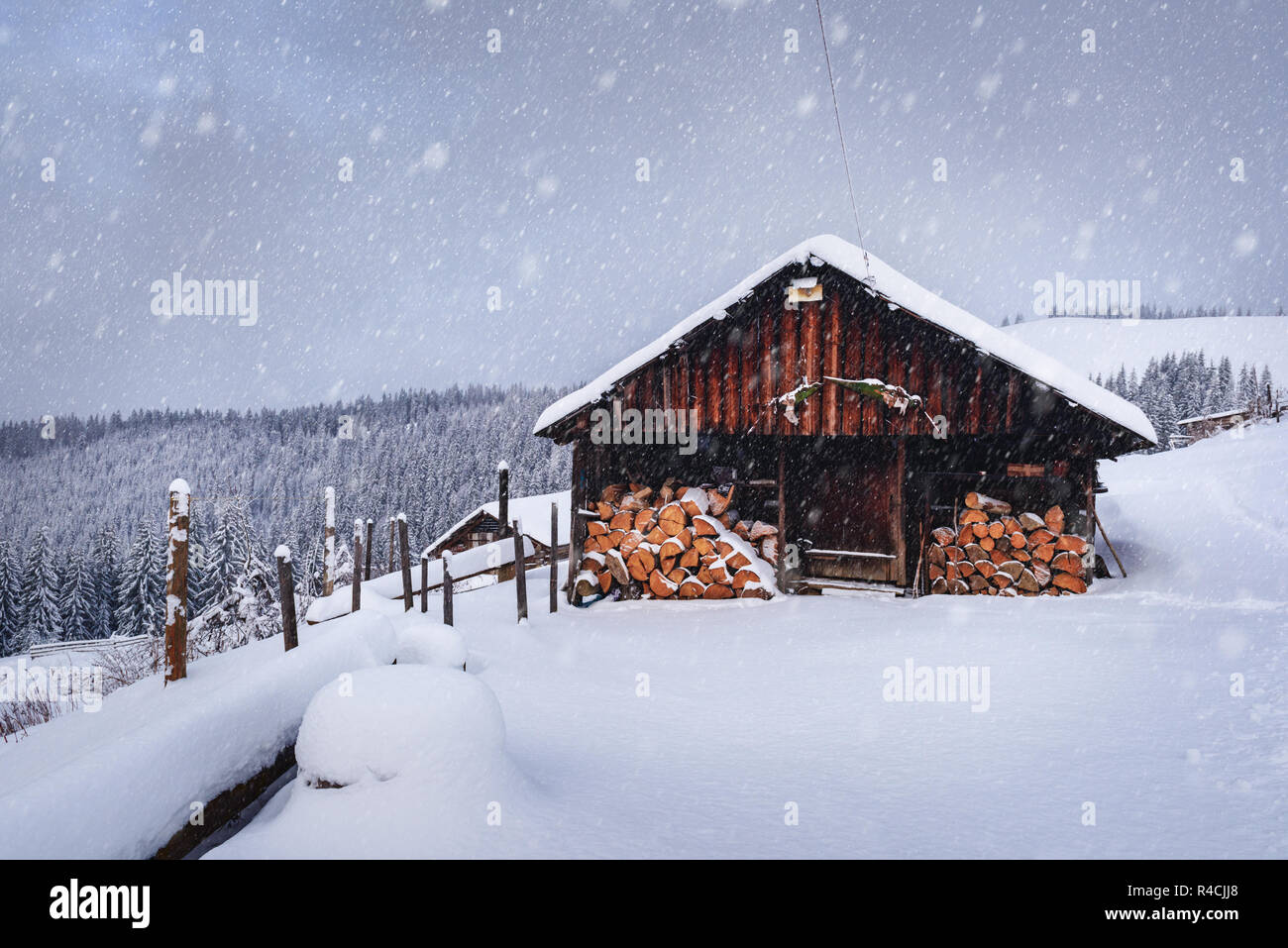 Paysage d'hiver fantastique avec maison en bois dans les montagnes enneigées. Concept de vacances de Noël. La montagne des Carpates, l'Ukraine, l'Europe Banque D'Images