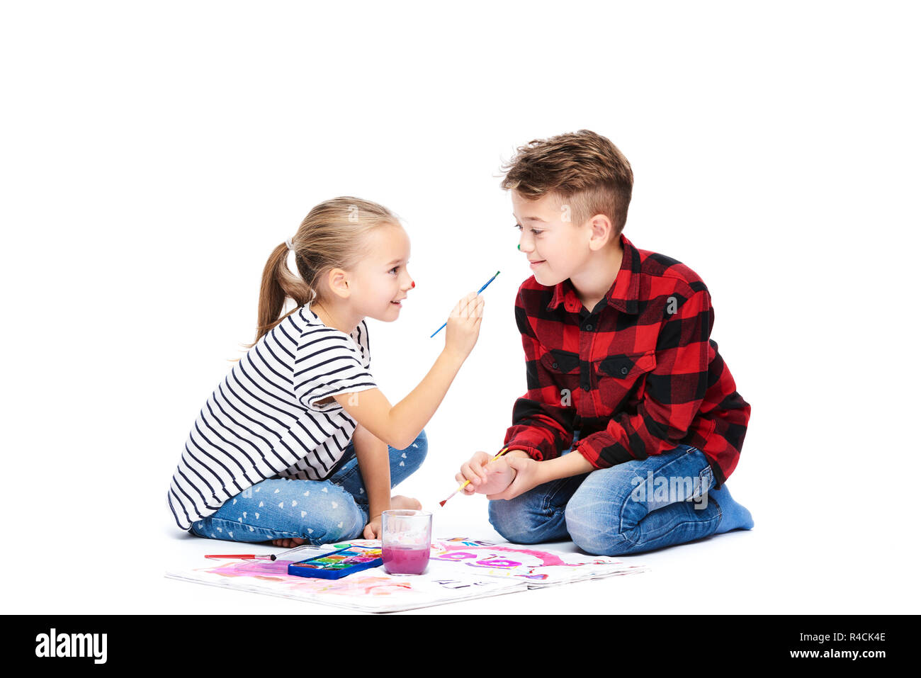 Frère et sœur s'amuser avec la peinture à l'aquarelle. Heureux enfants créatifs à la classe d'art. Concept art-thérapie sur fond blanc. Banque D'Images