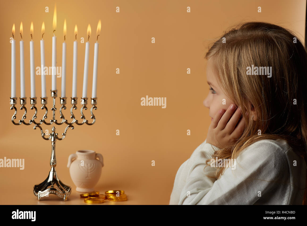 Fille charmante à la combustion de bougies à menorah Banque D'Images