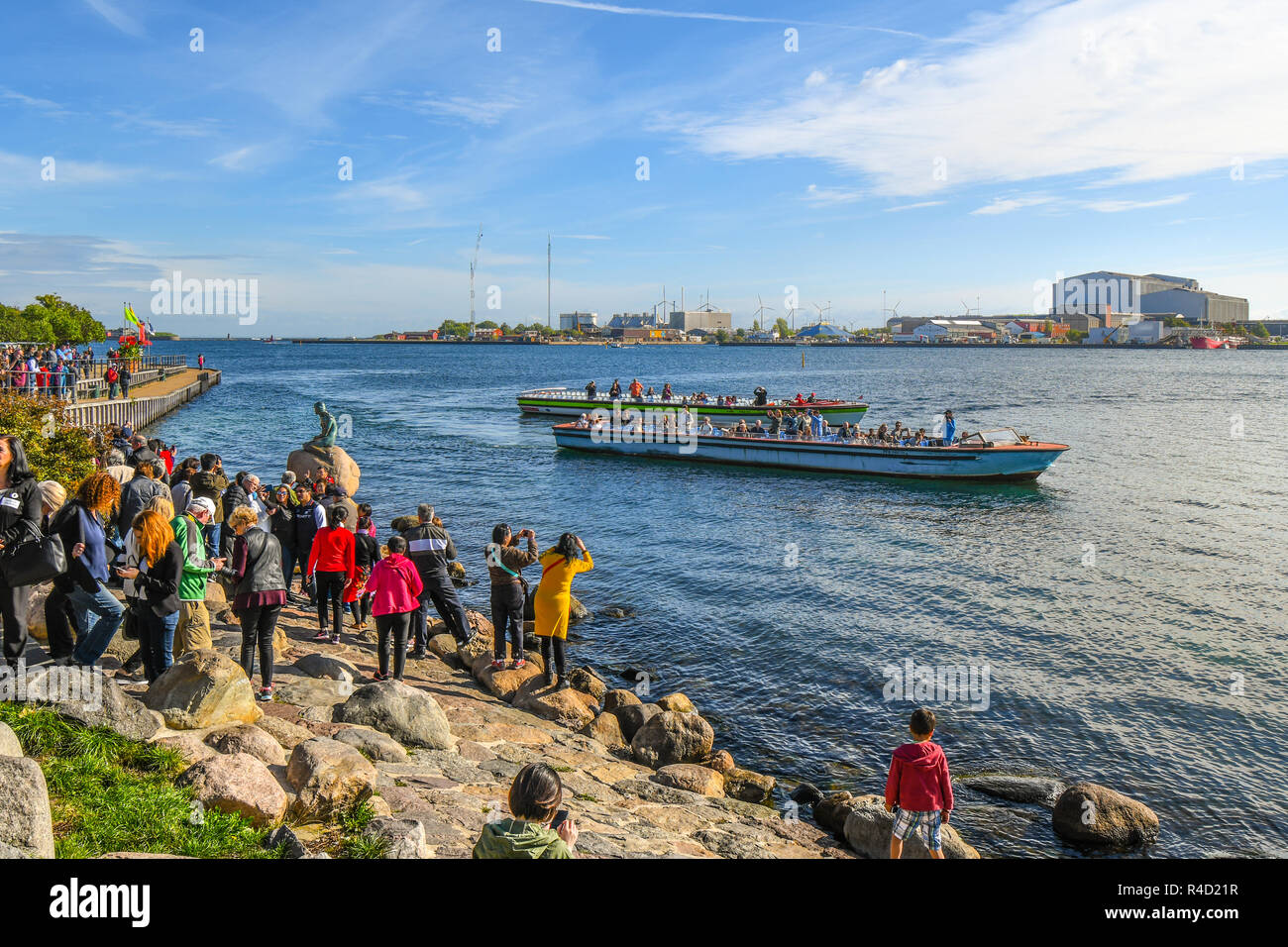 Les touristes entourent la statue de la Petite Sirène sur la promenade de Langelinie à Copenhague, au Danemark en tant que tour les bateaux flottent par. Banque D'Images Les touristes entourent la statue de la Petite Sirène sur la promenade de Langelinie à Copenhague, au Danemark en tant que tour les bateaux flottent par. Banque D'Images