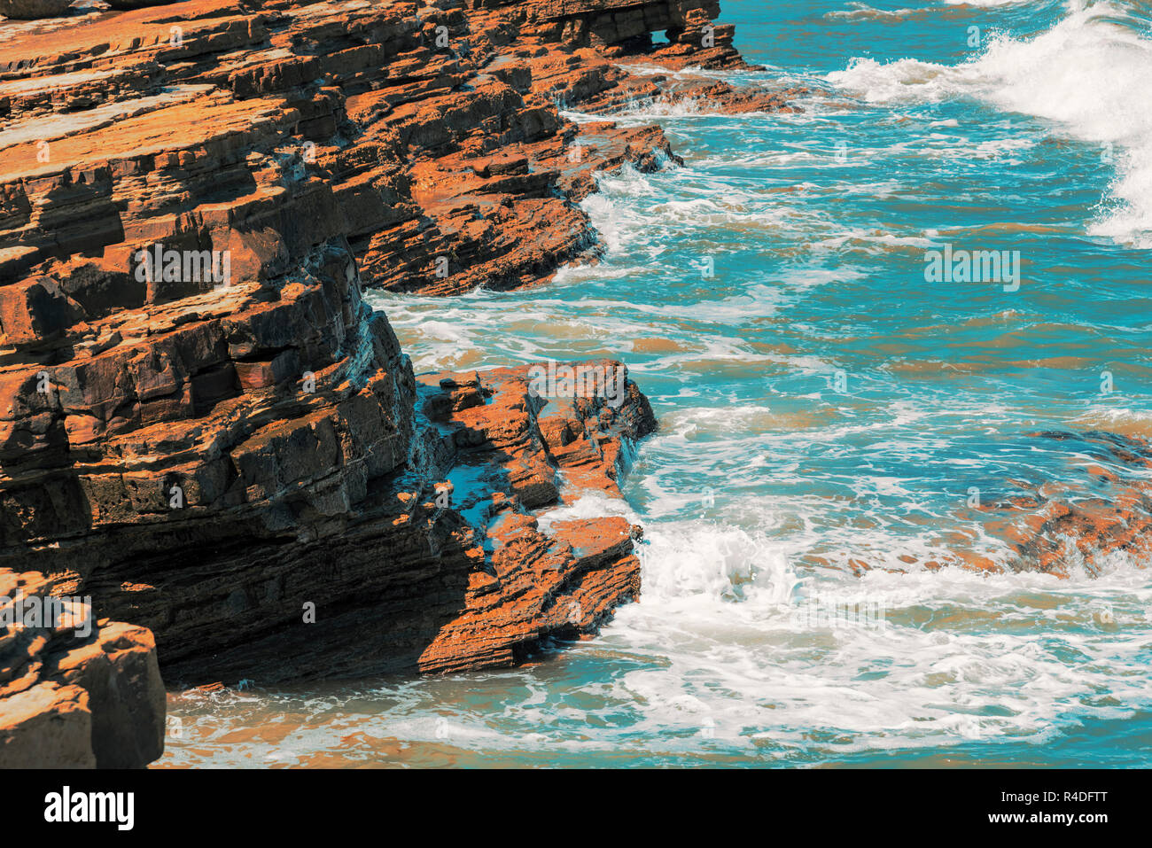 Blue ocean vagues se briser contre les falaises rocheuses et la côte. Banque D'Images