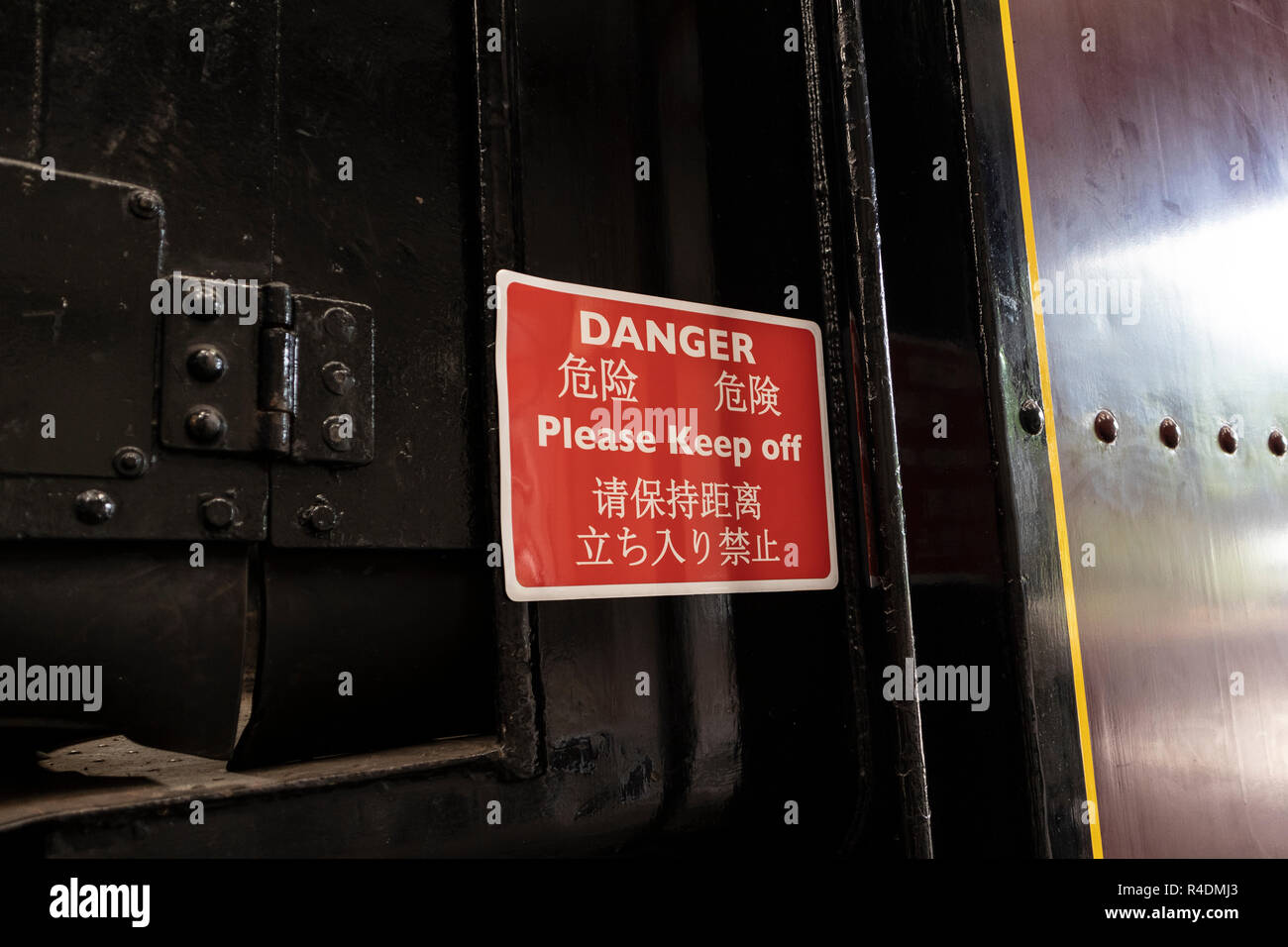 Le signe de danger en anglais et japonais sur une locomotive à vapeur à Lakeside et Haverthwaite que Steam Railway, Nr Ulverston, Cumbria, Lake District, UK Banque D'Images