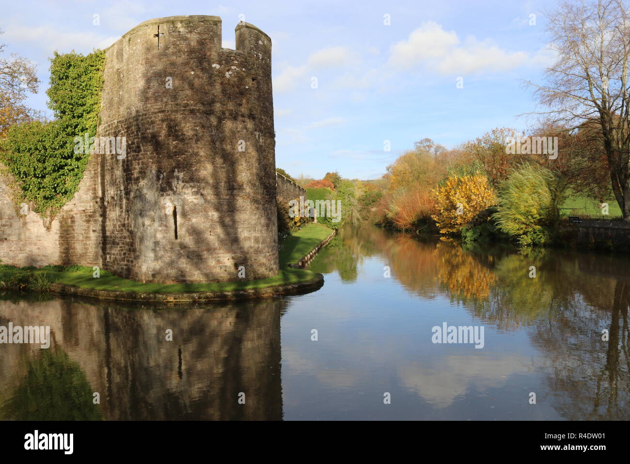 Murs extérieurs et des douves du palais des évêques et des jardins dans les puits. Scène d'automne avec un mur extérieur d'un palais. Wells, Somerset, England, UK. Banque D'Images