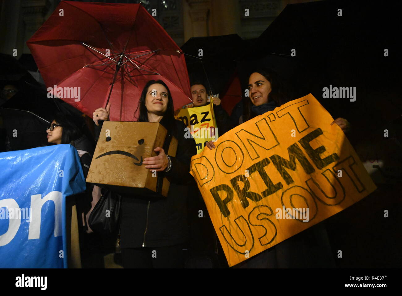 Queens, New York, USA. 26 Nov 2018 des pluies sur une cyber lundi, les manifestants, certains chargés de boîtes portant une version satirique de l'Amazon logo, rassemblement contre le géant de la vente au détail en vue de bâtir un de son nouveau siège dans le Queens, New York. Leurs objections : 2,5 milliards de dollars en subventions de l'État de New York pour le projet et la peur qu'il va nuire à l'industrie existante et augmenter le coût du logement. Crédit : Joseph Reid/Alamy Live News Banque D'Images