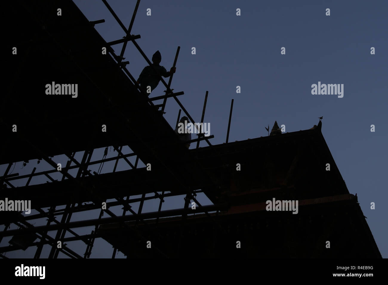 Kathmandu, Népal. 27 Nov, 2018. Les travailleurs sont en silhouette comme ils se tiennent au sommet d'un temple en reconstruction à Kathmandu, Népal le Mardi, Novembre 27, 2018. Credit : Skanda Gautam/ZUMA/Alamy Fil Live News Banque D'Images