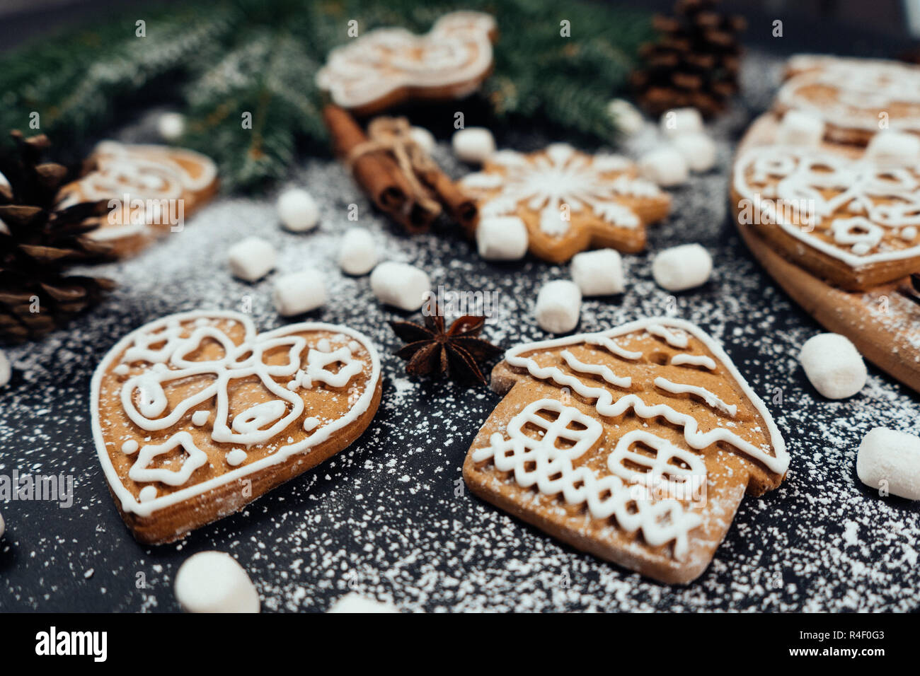 Close up Christmas gingerbread cookies au coeur et de la chambre forme sur la table avec marshmellows et autres décorations. Banque D'Images