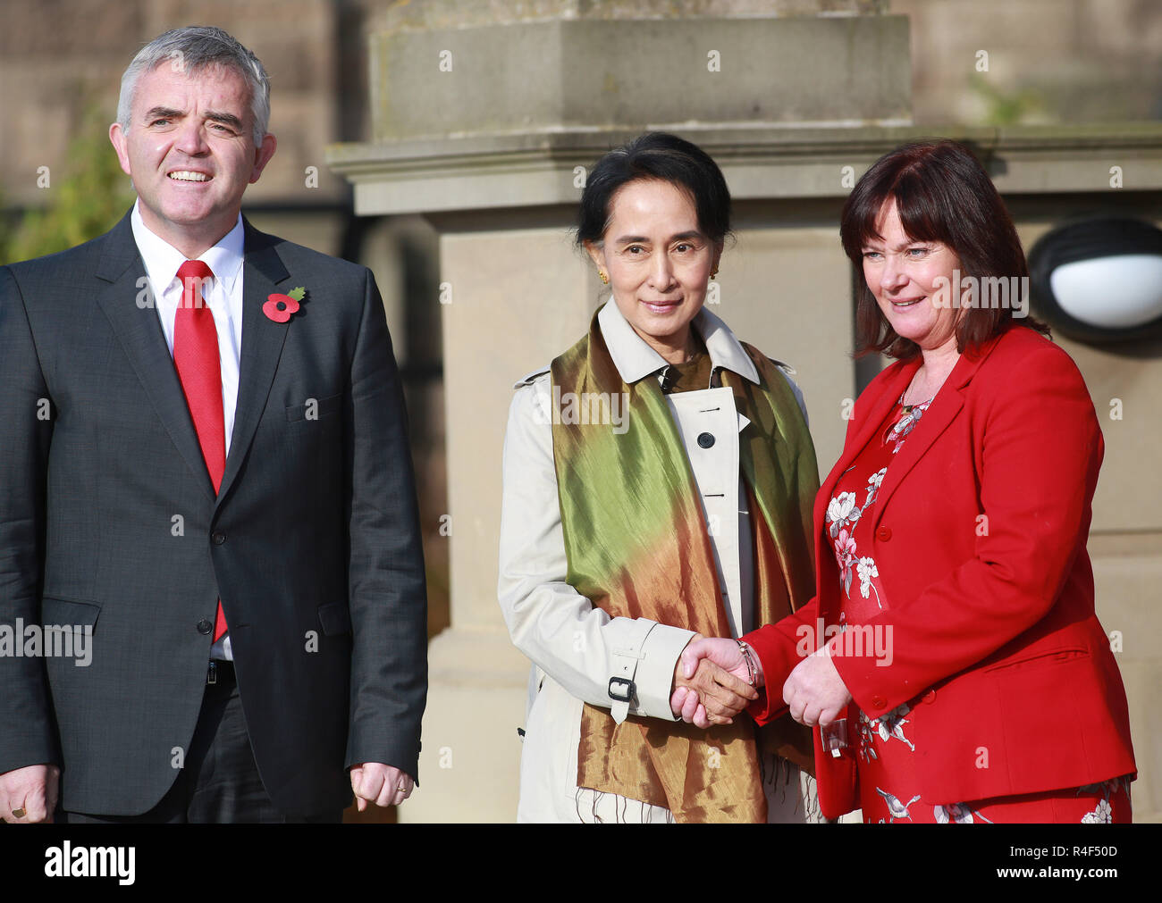 Chef de l'opposition birmane Aung San Suu Kyi est accueilli par les ministres Junior, Jonathan Bell et Jennifer McCann du bureau du premier ministre et vice-Premier ministres en tant qu'elle est arrivée à Stormont Castle à Belfast, en Irlande du Nord Jeudi, août 24th, 2013. Suu Kyi est sur un tour de deux semaines de l'Europe qui inclura aussi les arrêts à l'Italie. Photo/Paul McErlane Banque D'Images
