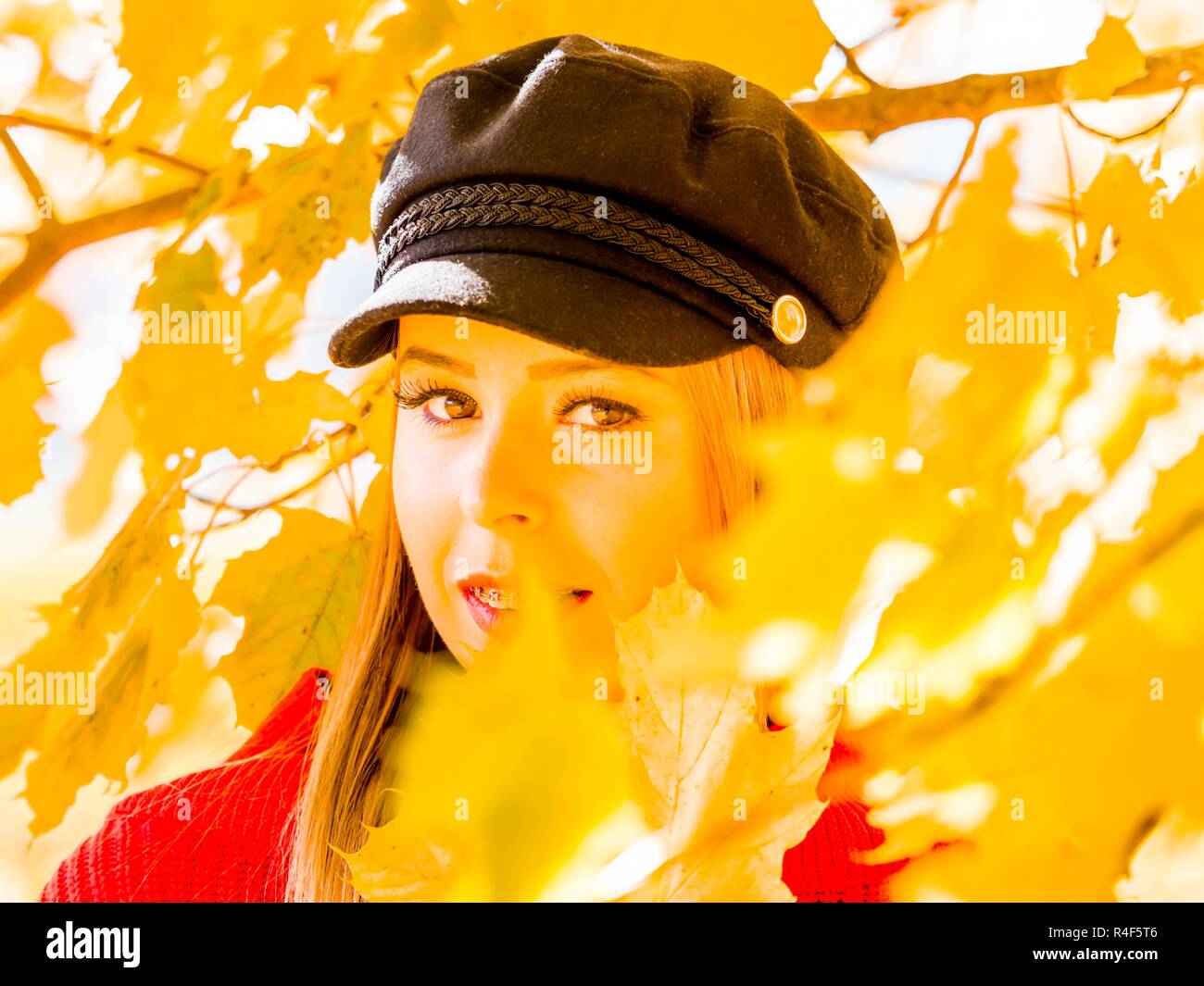 Adolescent portrait eyeshot tête de feu debout au milieu de la saison automnale automnale forêt branches feuilles de lueur dorée Banque D'Images