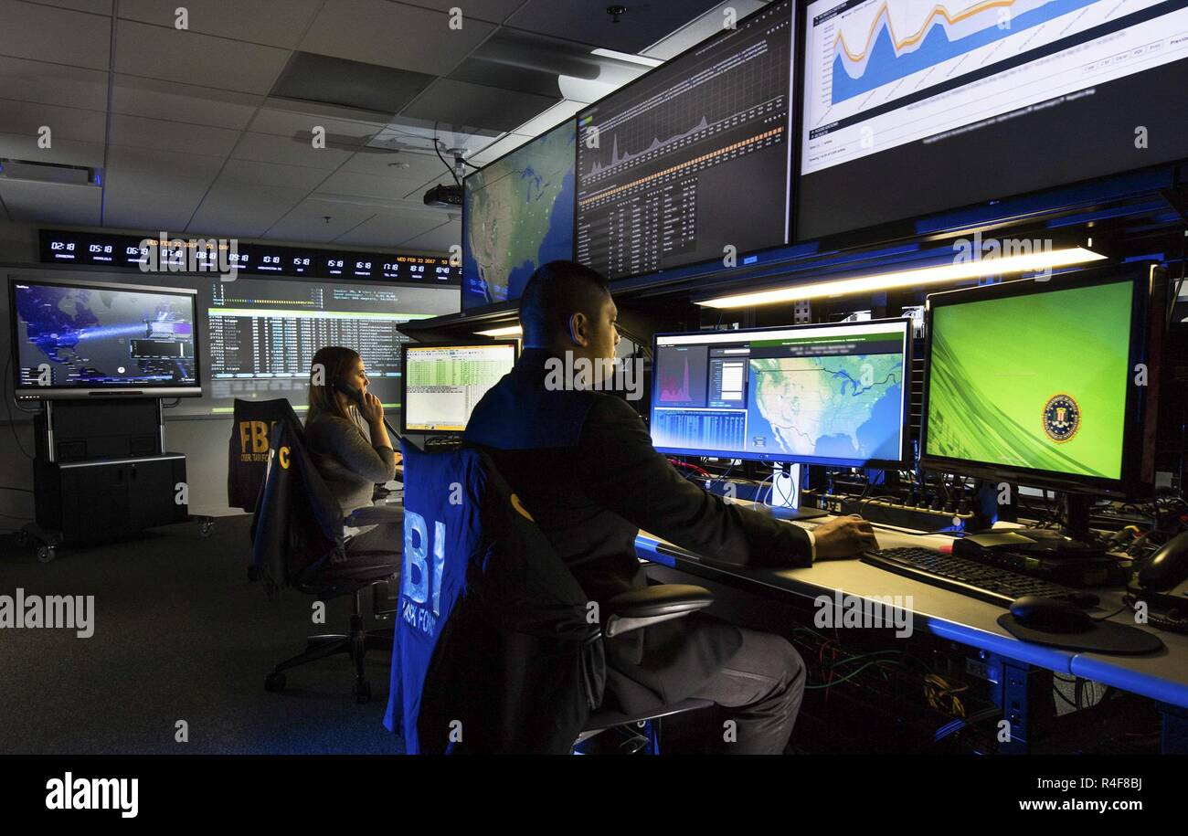 Federal Bureau of Investigation (FBI - -les agents travaillent à l'ordinateur dans le bureau de la division des crimes cybernétiques. Le FBI Cyber Division est une division Bureau fédéral d'investigation qui dirige l'effort national pour enquêter et poursuivre les crimes sur Internet, y compris les "cyber basé le terrorisme, l'espionnage, les intrusions informatiques, et les grands la cyberfraude.' Cette division du FBI utilise l'information recueillie pendant l'enquête pour informer le public des tendances actuelles en matière de cyber-crime.Federal Bureau of Investigation Il est axé autour de trois grandes priorités : l'intrusion de l'ordinateur, le vol d'identité, et la cyberfraude. Banque D'Images